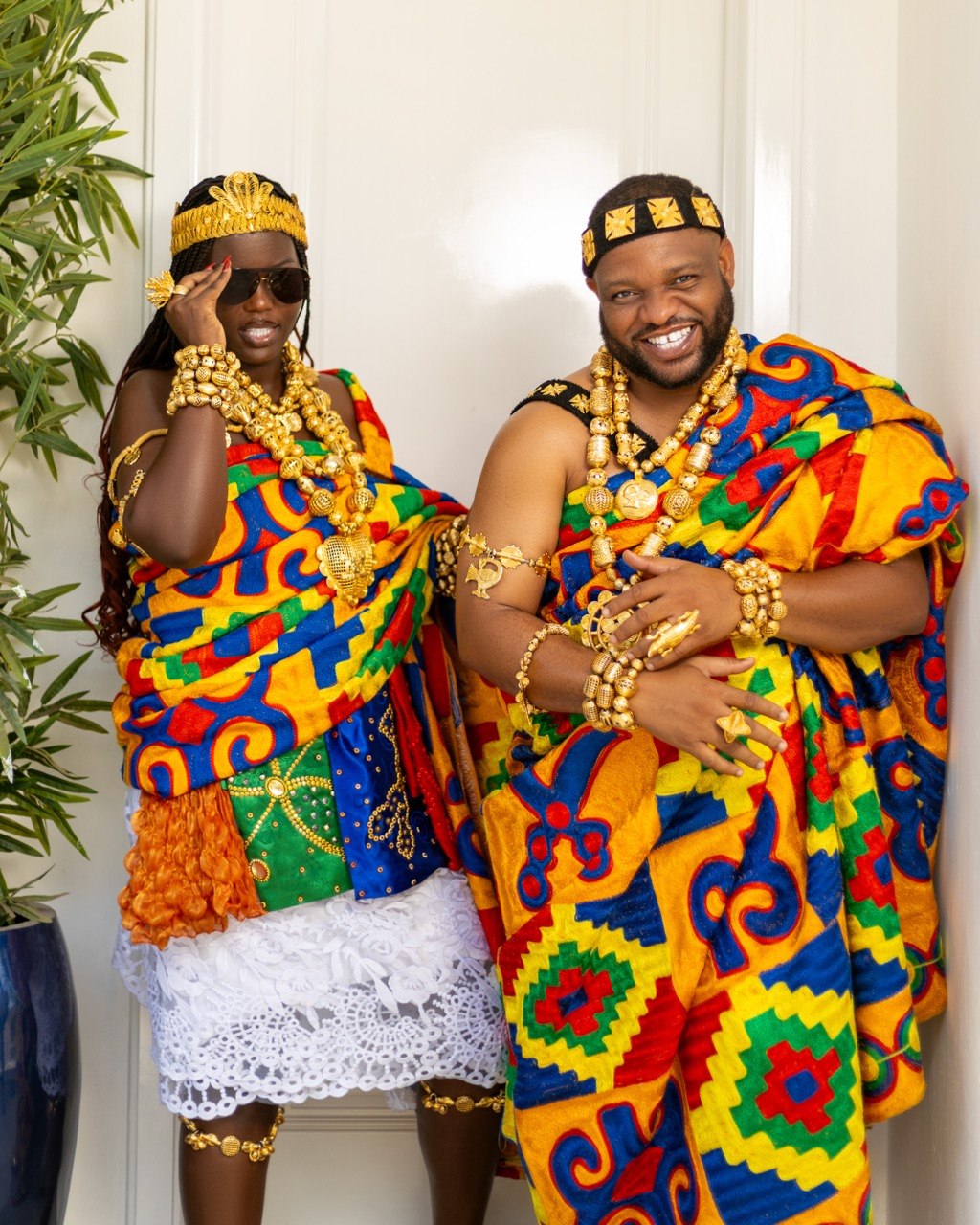 Claudine and Edward smiling together in kente, Claudine wearing sunglasses